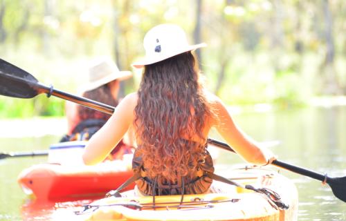 Women in kayaks paddling across the water